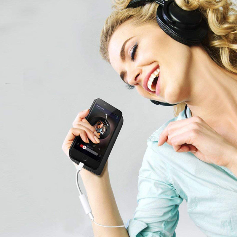 Woman wearing headphones and holding a smartphone with a music app on a light gray background