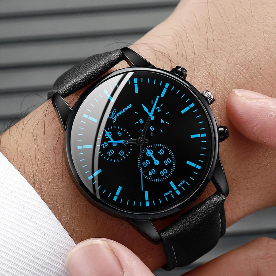 Black wristwatch with blue illuminated face on a person's wrist