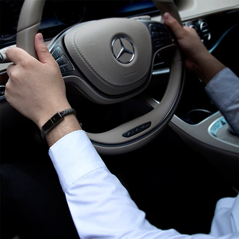 Person driving a car with a Mercedes-Benz steering wheel