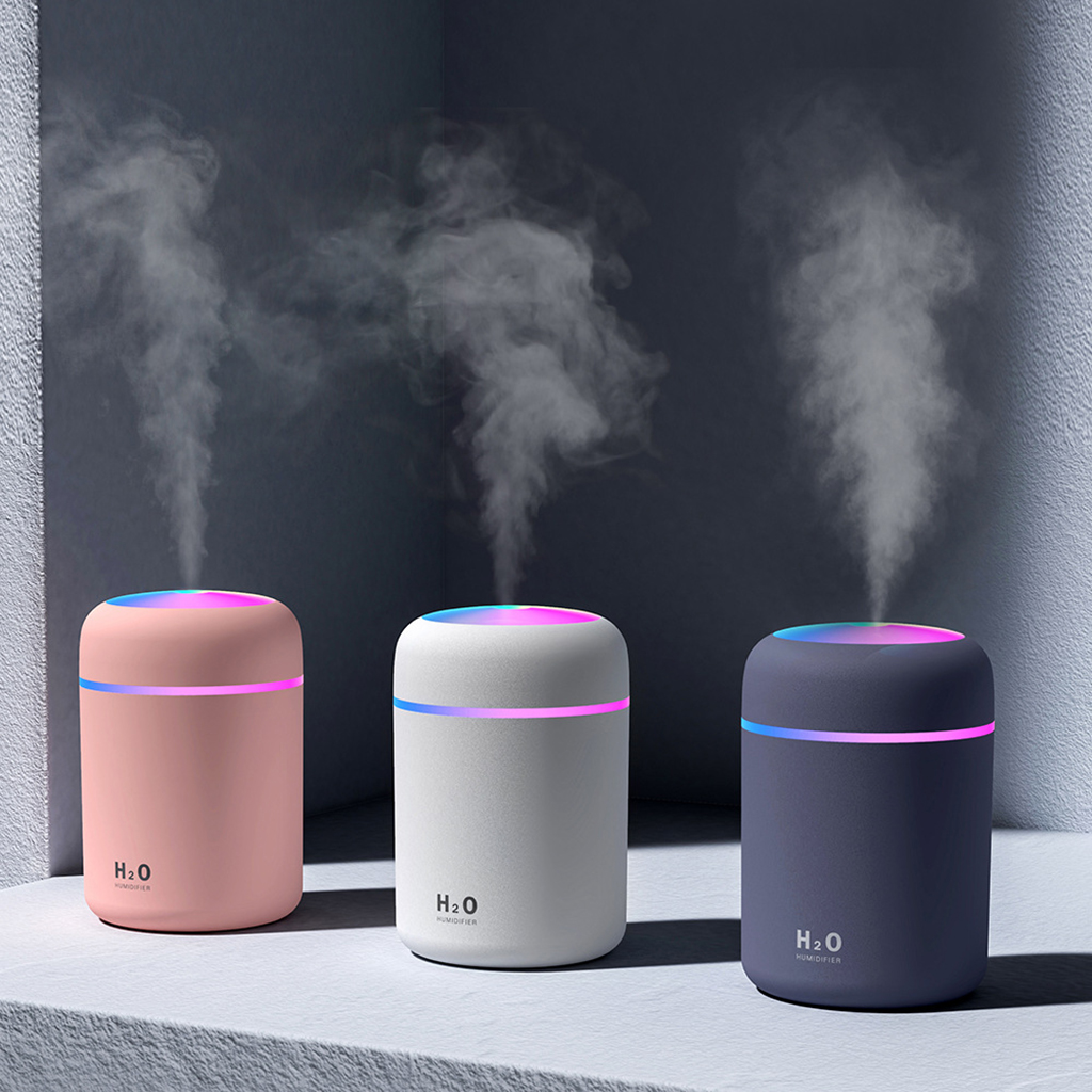 Three humidifiers with 'H2O' branding emitting mist against a dark background.