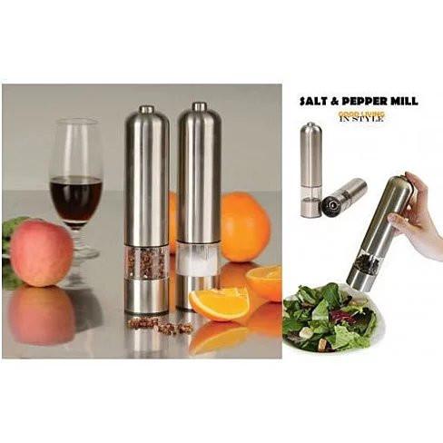 Stainless steel salt and pepper mill set with a glass of wine, fruit, and salad on a reflective surface.